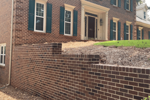 Professional brick retaining wall construction by skilled Hardscaping Contractor Indian Land, SC, featuring traditional red brick masonry