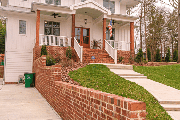 Elegant brick retaining wall and landscaping design by Hardscaping Contractor Waxhaw, NC, featuring traditional red brick construction