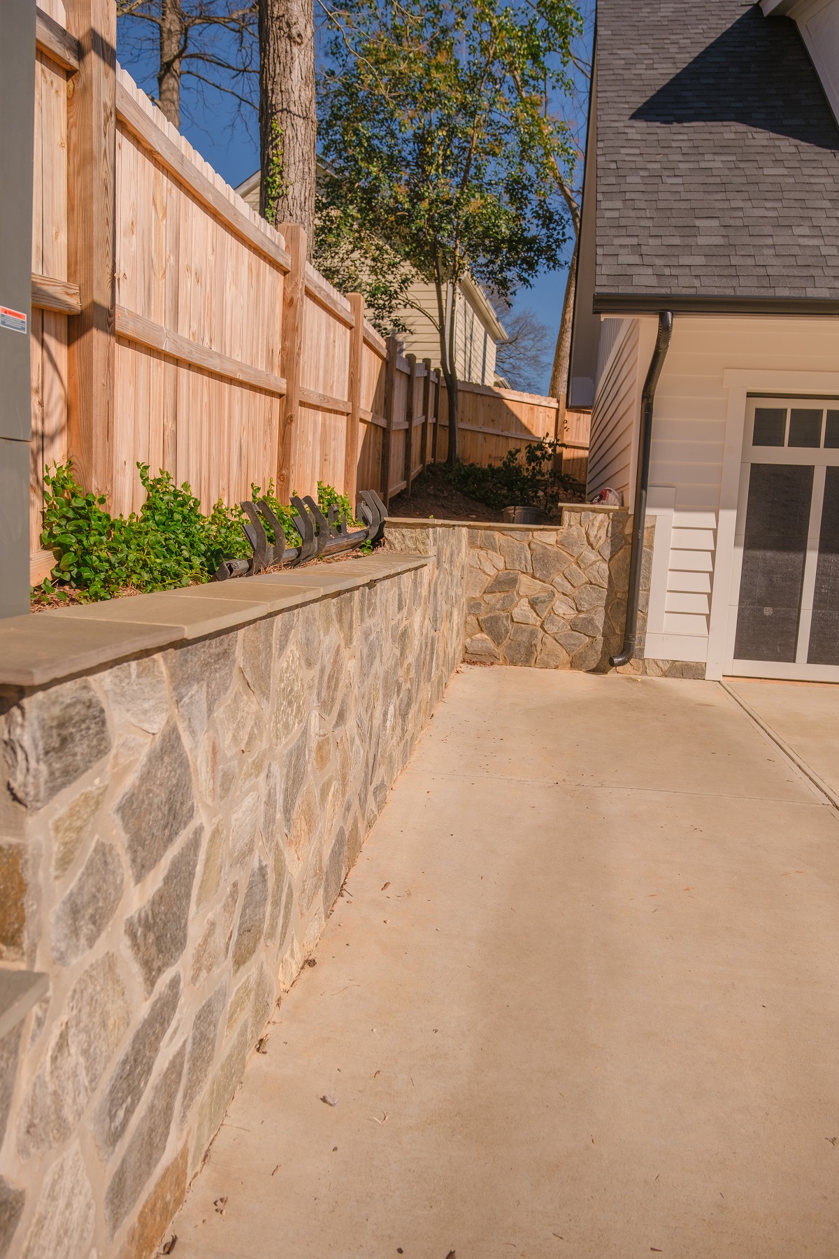 Natural stone retaining wall construction by professional Hardscaping contractor Belmont, NC, featuring fieldstone masonry
